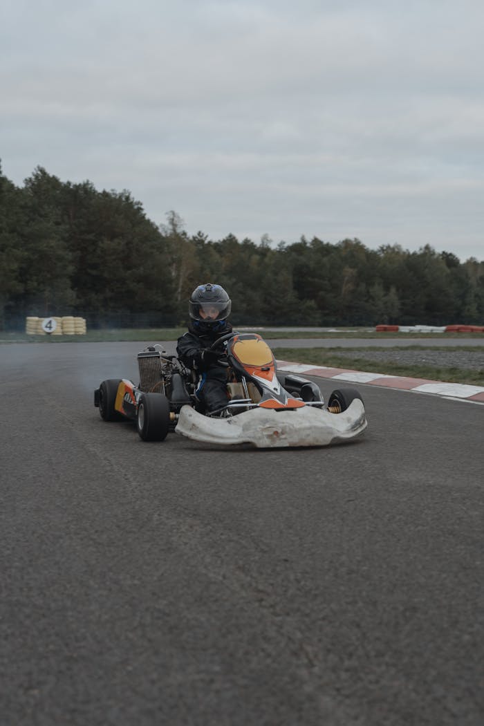 A thrilling go-kart race with a driver speeding on an outdoor track.